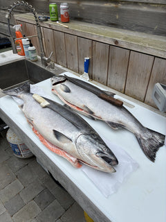 Two whole sockeye salmon on Big Fish cutting board with knives