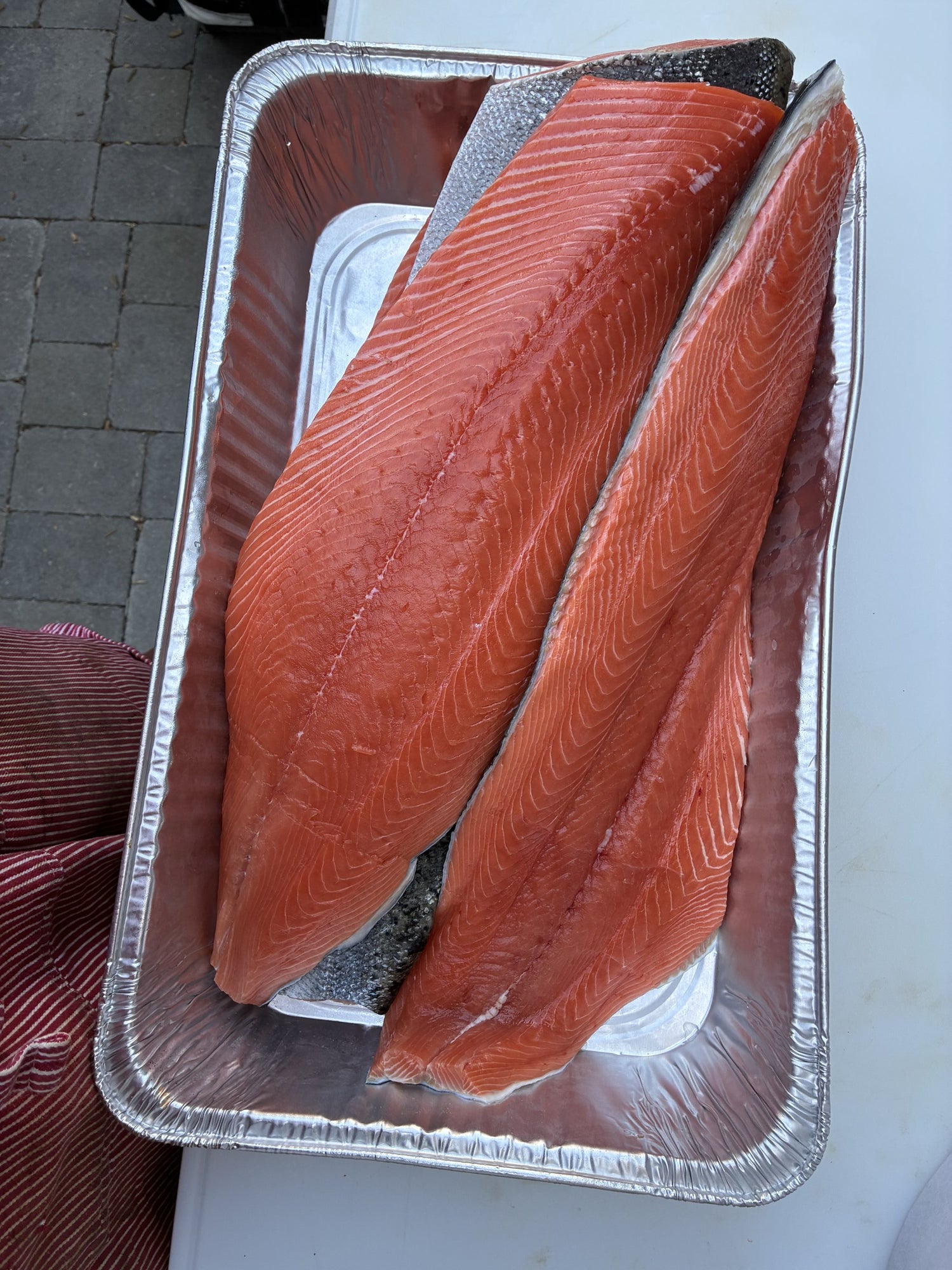 Two large salmon fillets in foil pan ready for smoker