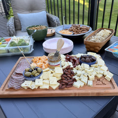 Walnut board with charcuterie spread on outdoor deck